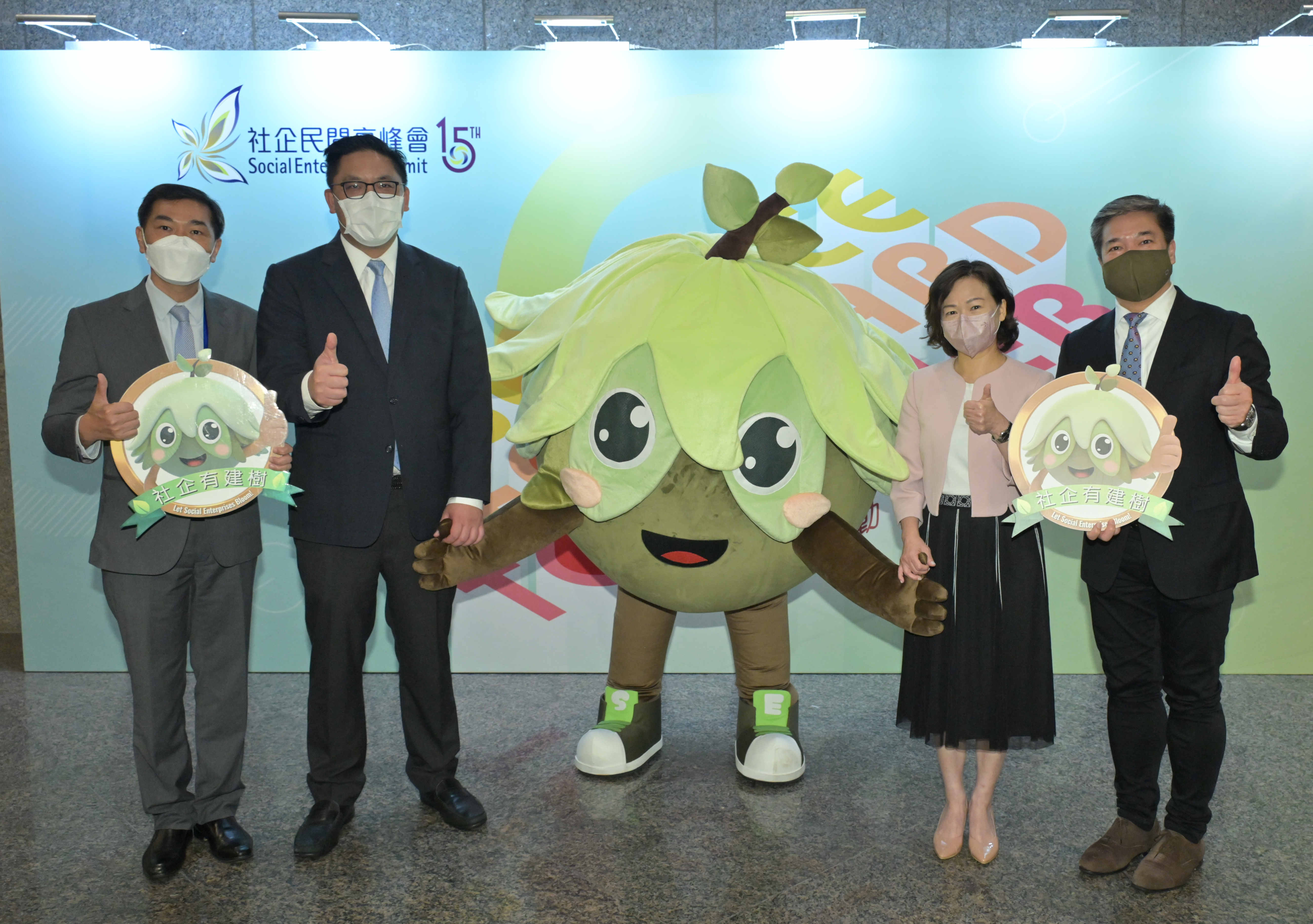 (From left) the Chairman of the Advisory Committee on the Enhancing Self-Reliance through District Partnership Programme, Mr Ricky Wong; the Under Secretary for Home and Youth Affairs, Mr Clarence Leung; Bloomy the Tree; the Director of Home Affairs, Mrs Alice Cheung; and the Chairperson of the Hong Kong Social Entrepreneurship Forum, Mr Alan Cheung, at the opening ceremony.